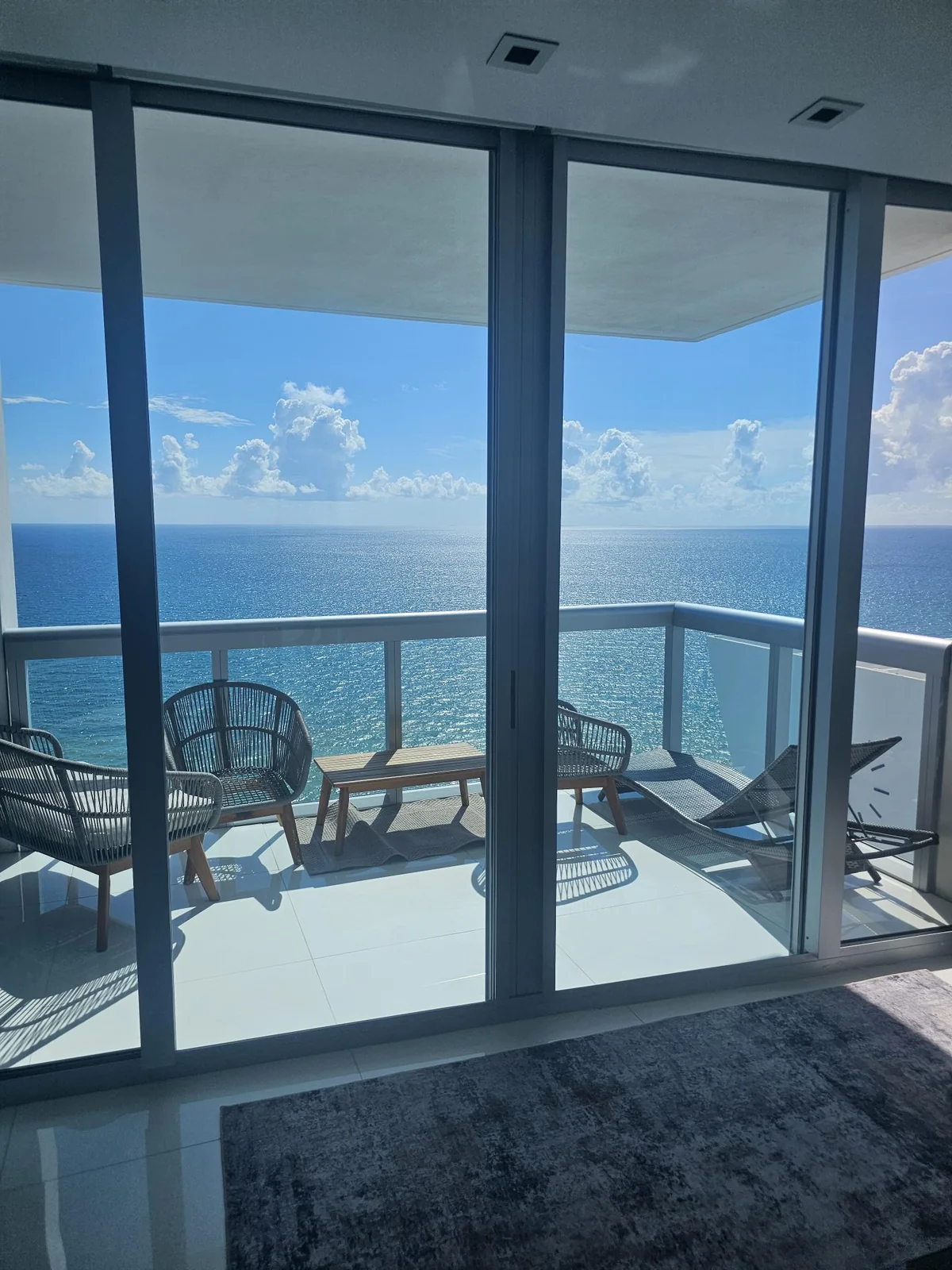 Sliding glass door opening from a room onto an ocean-facing balcony