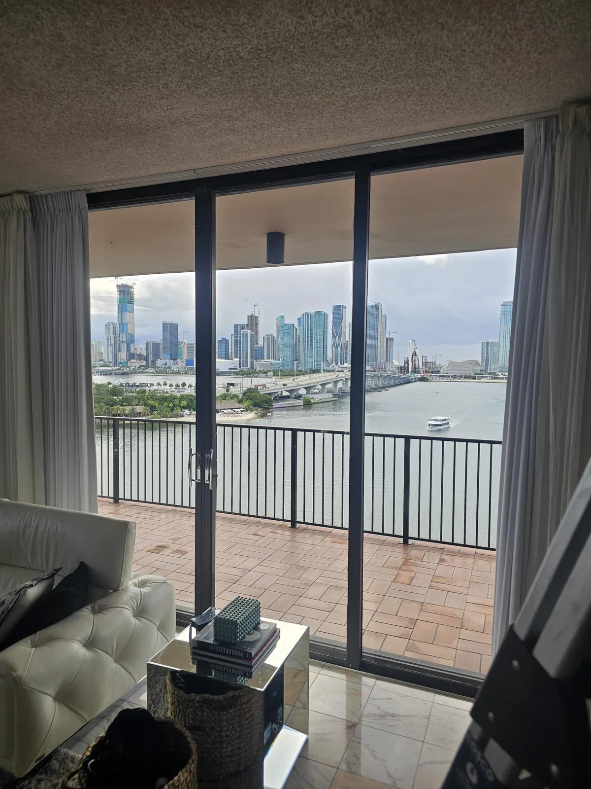 Residential balcony sliding door Sliding glass door panels viewed from a living room with a balcony and skyline beyond